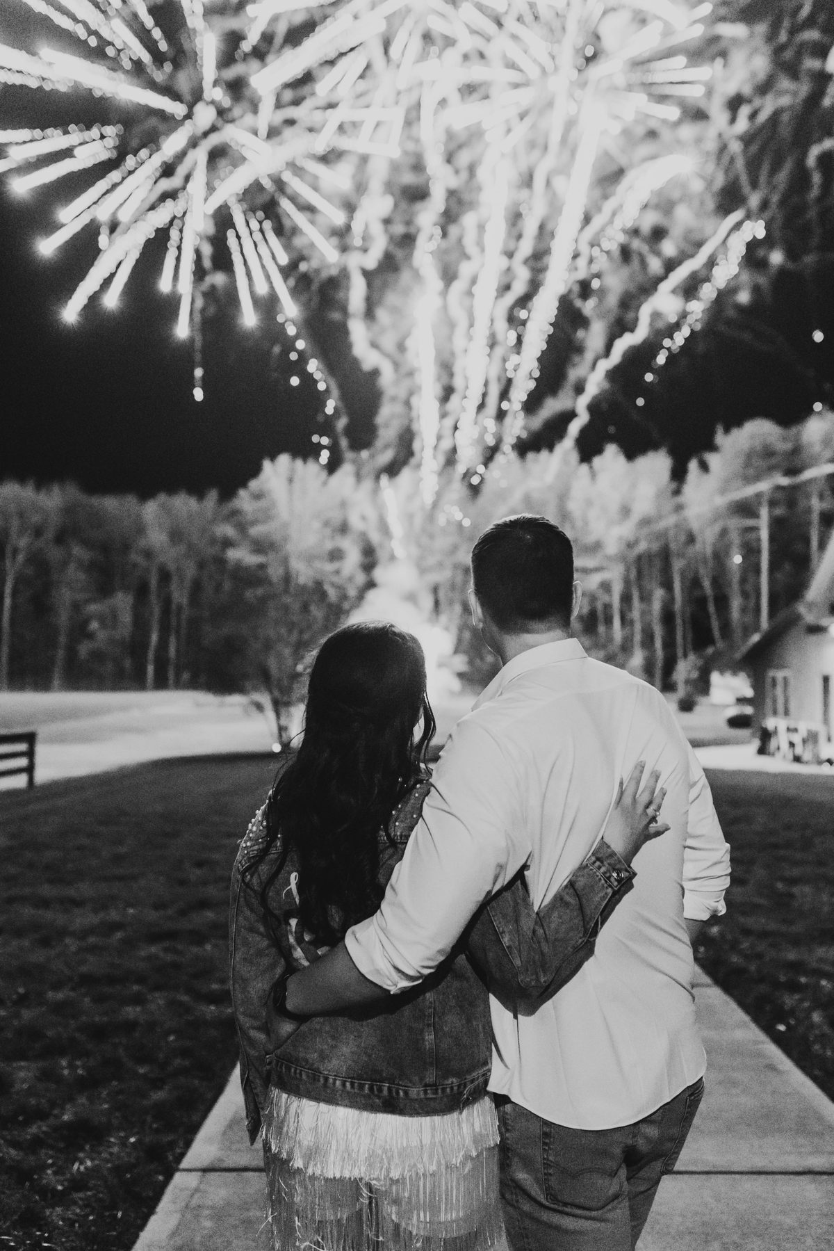 Black and white photo of a couple watching their wedding fireworks